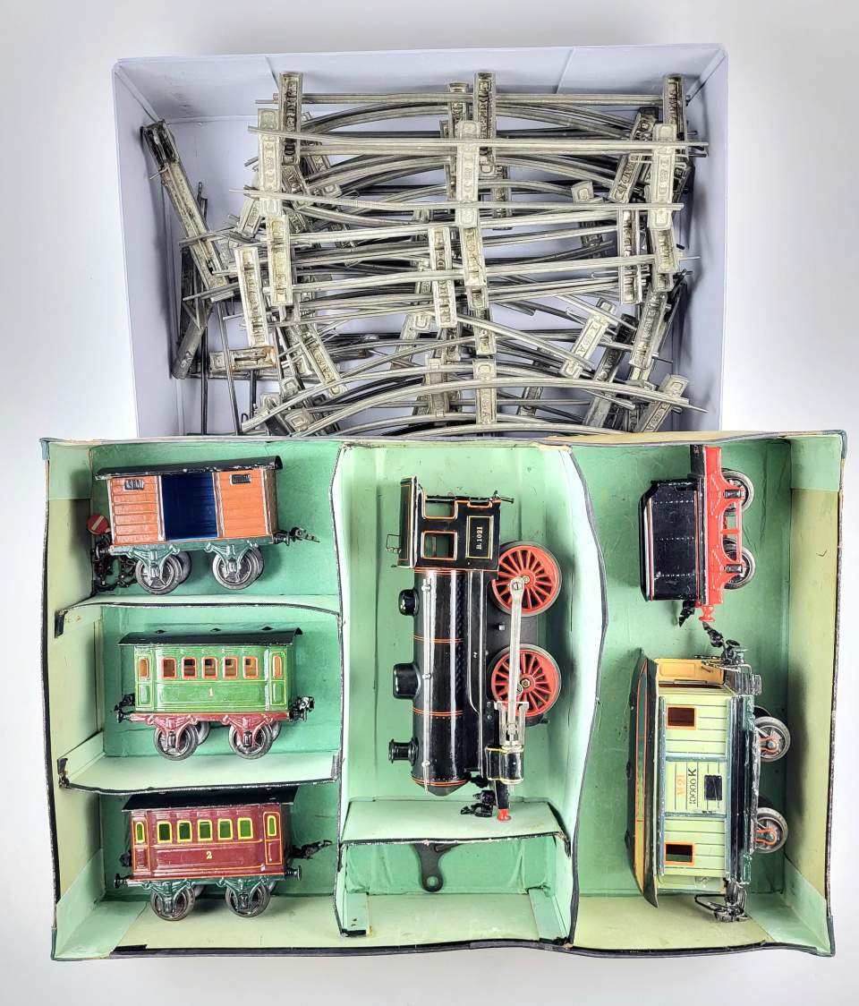 Märklin Spielzeug-Eisenbahn in Originalschachtel, Modelleisenbahn mit Uhrwerksdampflokomotive. Schienen und Weichen